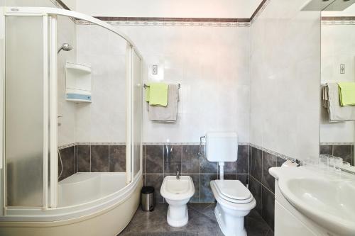 ein Badezimmer mit Badewanne, Toilette und Waschbecken in der Unterkunft Apartment Bellavista Sea View in Umag