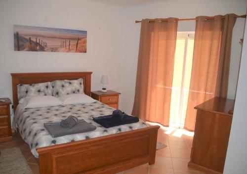 una camera da letto con un letto con due asciugamani sopra di Casa Flora T1 - Vila do Bispo a Vila do Bispo