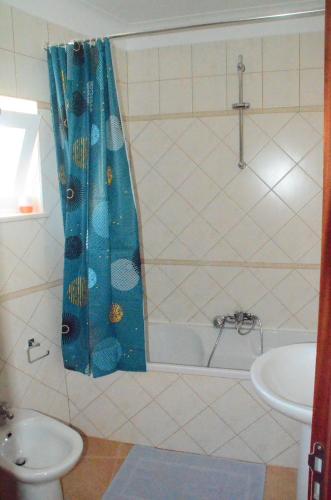 baño con cortina de ducha azul y lavamanos en Casa Flora T1 - Vila do Bispo, en Vila do Bispo