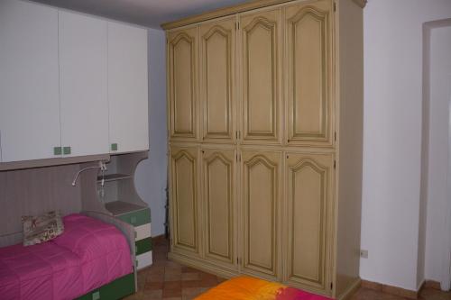 ein Schlafzimmer mit einem großen Holzschrank neben einem Bett in der Unterkunft Da Vici in La Spezia