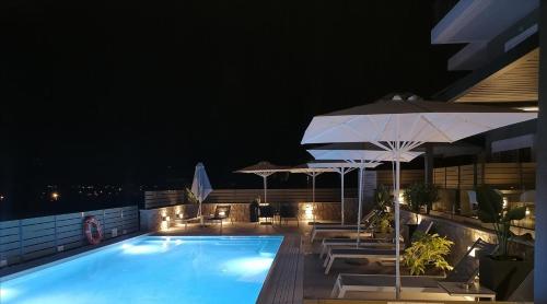 a large swimming pool with a balcony overlooking a city at Andrew's Luxury Residence in Nafplio