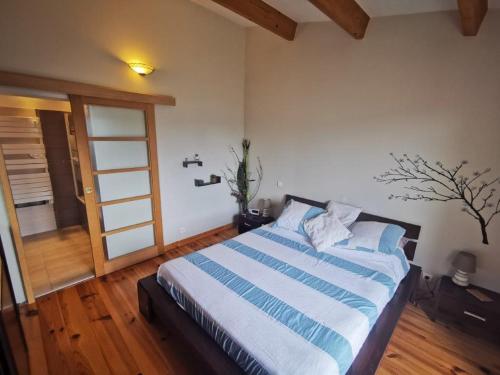 une chambre avec un lit à rayures bleues et blanches dans l'établissement Côte d'Azur Villa Amicalement Hôte, à Coursegoules