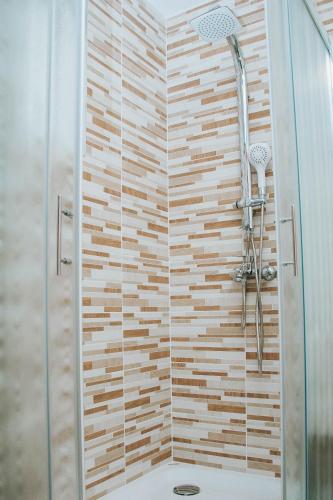 Un baño con ducha con puerta de cristal. en Apartment Bor, en Bovec
