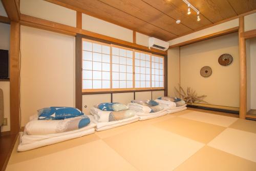 a room with a row of pillows on the floor at Hokusai Stay in Osaka