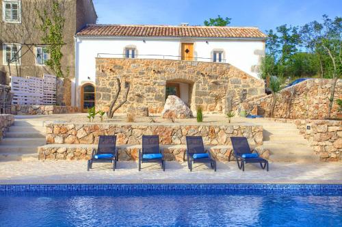 a group of chairs sitting next to a swimming pool at Villa MAY in Gostinjac