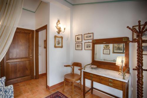 a dressing room with a mirror and a wooden dresser at La Renaia in Cortona