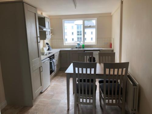 a small kitchen with a table and chairs in it at Queen Street Apartments in Enniskillen