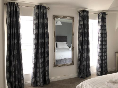 a bedroom with black curtains and a mirror at Queen Street Apartments in Enniskillen