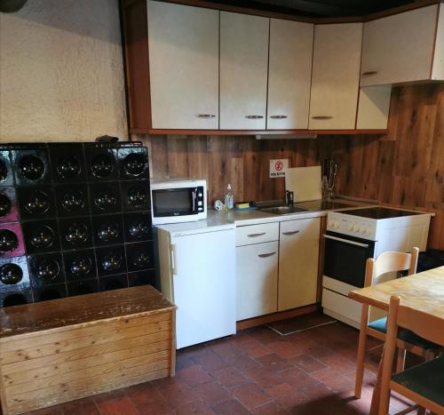 uma cozinha com electrodomésticos brancos, armários de madeira e uma mesa em Chalet Ruša em Bohinj