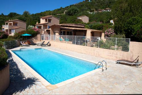a swimming pool in front of a house at Résidence U LATONU - Palombaggia in Porto-Vecchio