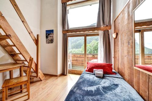 a bedroom with a bed and a large window at Hôtel Restaurant Gîtes Les 5 Saisons in Freissinieres