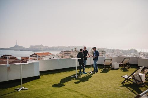a group of three people standing at a table on a balcony at SubUp Hostel in Cabo de Palos