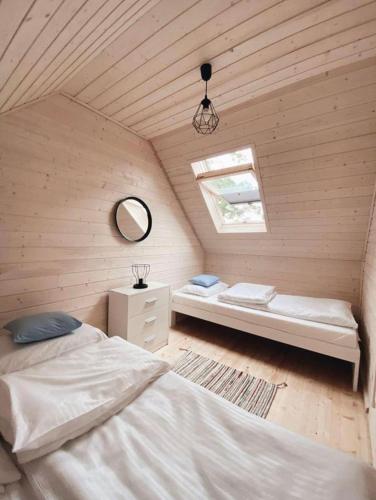 a room with two beds and a window and a mirror at Nad Rozlewiskiem in Bobolin