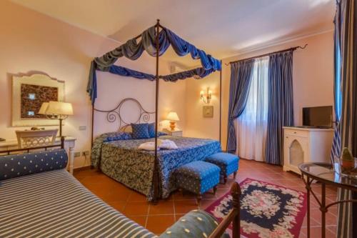 ein Schlafzimmer mit einem Himmelbett und einem Sofa in der Unterkunft Il Borgo Country Resort in Castiglione di Sicilia