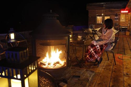a woman sitting in a chair in front of a fireplace at MARINE-Q in Inami