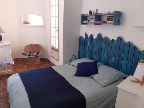 un letto con testiera blu in una stanza di T2 rénové 100m plage avec SPA privatif entre calvi et ile rousse a Lumio