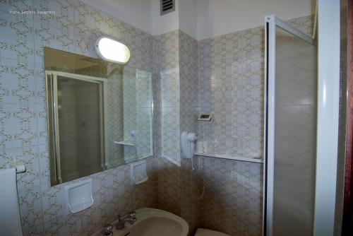La salle de bains est pourvue d'un lavabo et d'une douche avec un miroir. dans l'établissement Hotel Gli Ulivi, à Soverato Marina