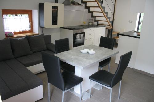a kitchen and living room with a table and chairs at Apartments Jez in Slap ob Idrijci