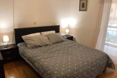 una camera da letto con un grande letto con due comodini di Cosy & Functional pied-à-terre ad Atene
