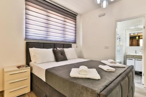 a bedroom with a large bed with two towels on it at Lux Apartmani Djukic in Bar