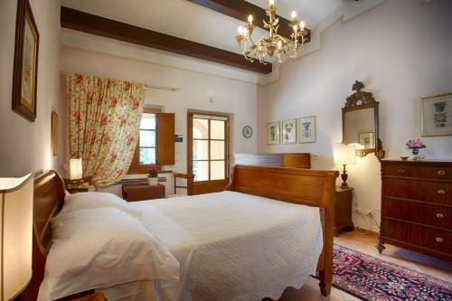 a bedroom with a bed and a dresser and a chandelier at La Renaia in Cortona