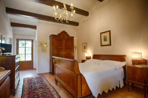 a bedroom with a bed and a chandelier at La Renaia in Cortona