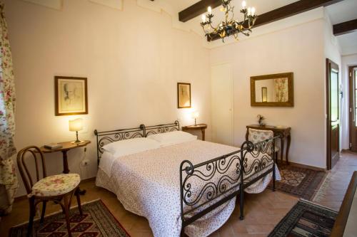 a bedroom with a bed and two tables and a chandelier at La Renaia in Cortona
