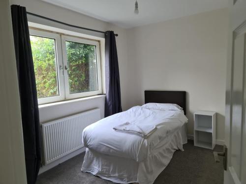 een slaapkamer met een wit bed en een raam bij Harding Row in Norton