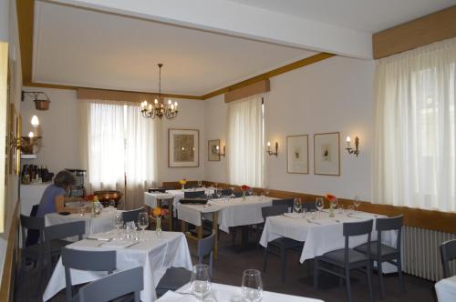 a dining room with white tables and chairs at Albergo Svizzero in Biasca