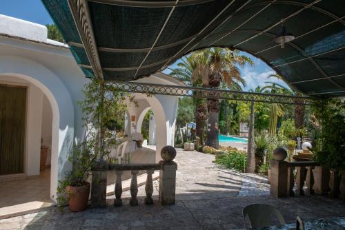 uma casa com um arco e uma piscina em La Villa di Anglani em Carovigno