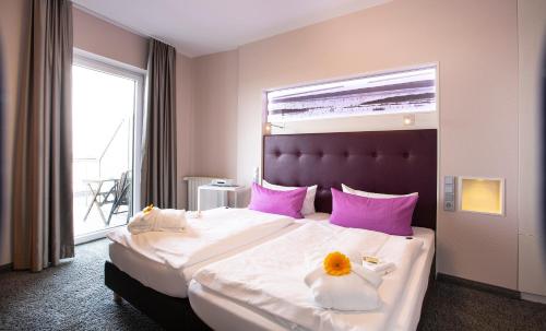 a hotel room with a large bed with flowers on it at Hotel Fährhaus in Norddeich