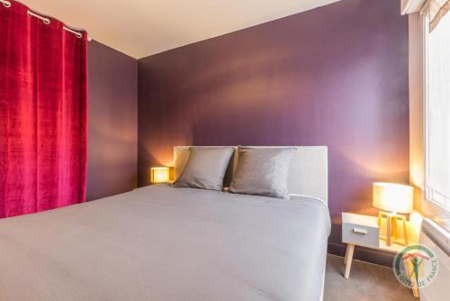 een slaapkamer met een bed en een rood gordijn bij Et si on restait en Normandie ? in Caen