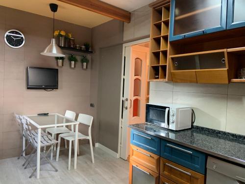 a kitchen with a table with chairs and a microwave at Casa Cambrils Bahia in Cambrils