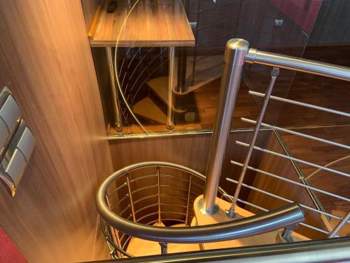 a wooden staircase with a metal rail and a chair at Casa Cambrils Bahia in Cambrils