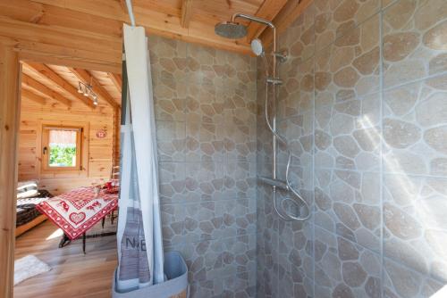 een badkamer met een douche en een stenen muur bij Chalet & SPA sur la Côte Fleurie in Auberville