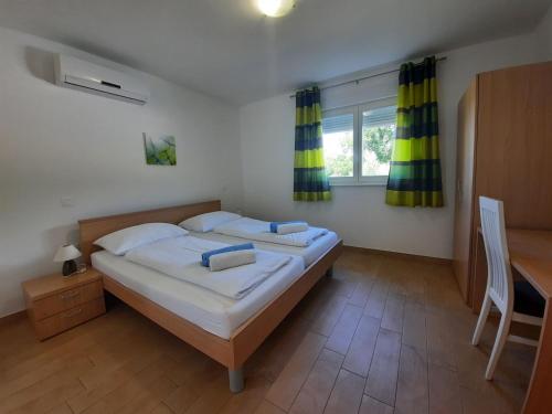 a bedroom with a bed and a desk and a window at VILLA DIAMOND YourCroatiaHoliday in Drenje