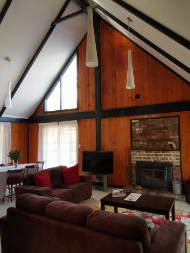 a living room with two couches and a fireplace at Hunter Habit Cottages in Rothbury