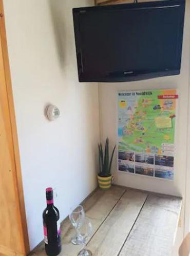 a bottle of wine and two wine glasses on a table at Have a nice stay! - Beach Cottage free parking in Noordwijk aan Zee
