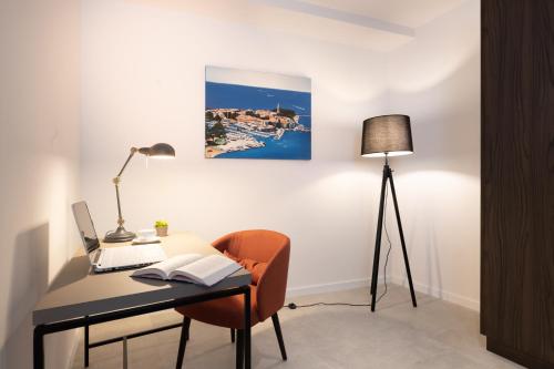 a living room with a desk and a lamp at Rivalmare Boutique Hotel in Novigrad Istria