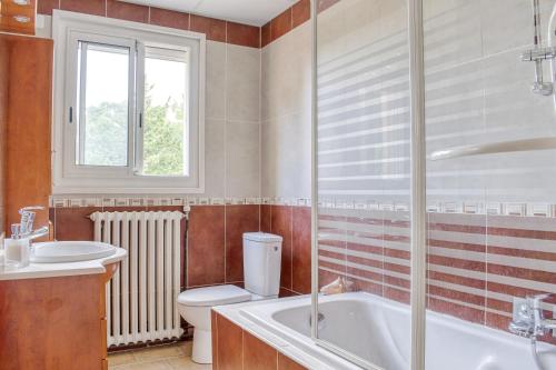 a bathroom with a tub and a toilet and a sink at Les Vignes de Carcassonne - Piscine et clim in Capendu