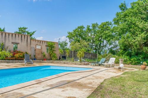 une piscine dans une cour avec des chaises et une maison dans l'établissement Les Vignes de Carcassonne - Piscine et clim, à Capendu
