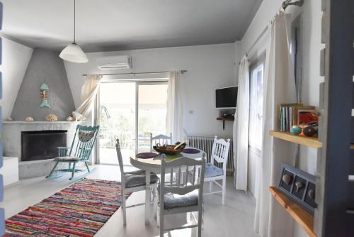 a living room with a table and chairs and a fireplace at jasmine apartments in Eretria