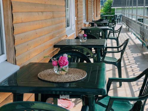 a row of tables and chairs on a porch with flowers at Отель Маленький Рай in Zatoka