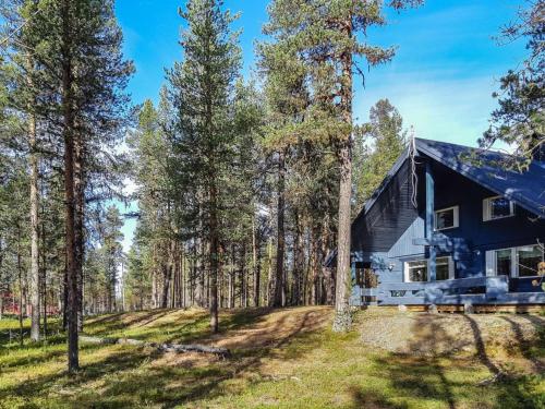 een zwart huis in het bos met bomen bij Holiday Home Antin mökki by Interhome in Ylikyro