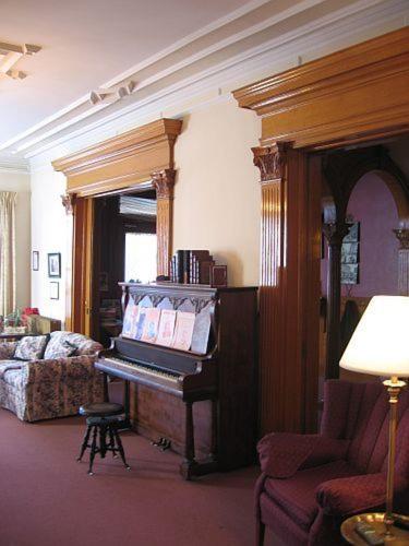 a living room with a piano and a couch at Olde Judge Mansion B&B in Troy