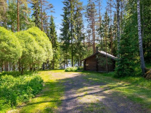 una cabaña en el bosque al lado de un camino de tierra en Holiday Home Oravanpesä by Interhome en Tuohikotti