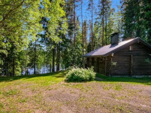 una cabaña de madera en medio de un bosque en Holiday Home Oravanpesä by Interhome en Tuohikotti
