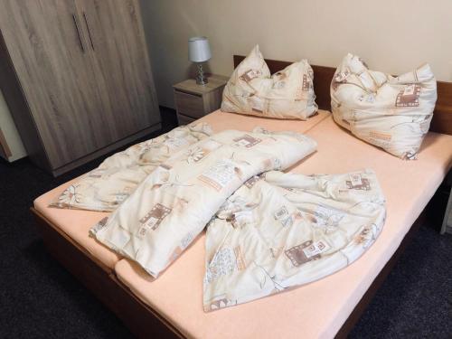 Una cama con mantas blancas y almohadas. en Penzion Nový mlýn, en Staré Splavy
