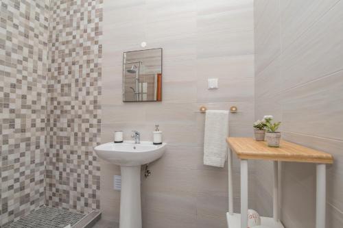 Un baño blanco con lavabo y ducha. en Casa Jacarandá, en Silves