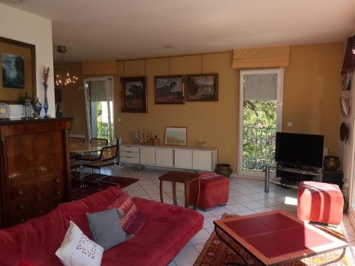 ヴィルヌーヴ・レ・ザヴィニョンにあるHoliday Home La Cigale by Interhomeのリビングルーム(赤いソファ、テレビ付)